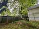 Fenced backyard with mature trees features a deck, providing privacy and security at 712 Garibaldi Sw St, Atlanta, GA 30310