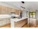 Modern kitchen boasts wood grain cabinets, stainless appliances, quartz counters, and a center island, seamlessly integrating with the living space at 105 Georgia Se Ave # 6, Atlanta, GA 30312