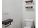 Modern bathroom with wood shelving, toilet, and floating towel holder at 165 Twin Lakes Dr, Covington, GA 30016