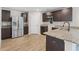 Well-lit kitchen boasts stainless steel appliances, dark cabinets, and beautiful granite countertops at 165 Twin Lakes Dr, Covington, GA 30016