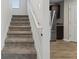 Carpeted staircase with white railing, leading to the upper level of the home at 165 Twin Lakes Dr, Covington, GA 30016