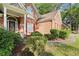 Close up of a charming brick house with a decorative front door and professionally landscaped bushes at 4635 Rutledge Dr, Snellville, GA 30039