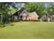 Well-maintained brick home with a spacious front yard, mature trees, and neatly trimmed hedges at 4635 Rutledge Dr, Snellville, GA 30039