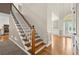 Bright foyer featuring hardwood floors, a staircase with white railings, and an arched entryway with decorative glass door at 4635 Rutledge Dr, Snellville, GA 30039