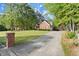 Brick home with a lengthy driveway, manicured lawn, and framed by mature trees at 4635 Rutledge Dr, Snellville, GA 30039