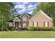 Charming two-story brick home with manicured lawn, lush landscaping, and a welcoming front entrance at 4635 Rutledge Dr, Snellville, GA 30039
