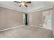 Cozy main bedroom featuring tray ceiling, ceiling fan, and a window with blue curtains at 4635 Rutledge Dr, Snellville, GA 30039
