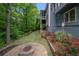 Landscaped backyard featuring a stone fire pit, lush lawn, and a variety of plants and trees at 4877 Registry Nw Ln, Kennesaw, GA 30152