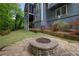 A backyard with a stone fire pit, a screened-in porch, and beautiful landscaping with flowers at 4877 Registry Nw Ln, Kennesaw, GA 30152