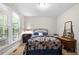 Bright bedroom featuring a patterned quilt, wooden furniture, and a large window overlooking a tree-filled landscape at 4877 Registry Nw Ln, Kennesaw, GA 30152