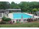 Inviting community pool area with lounge chairs, umbrellas, an iron fence, and landscaped flower beds at 4877 Registry Nw Ln, Kennesaw, GA 30152