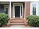 Classic brick home featuring a black front door with white trim and landscaped bushes at 4877 Registry Nw Ln, Kennesaw, GA 30152