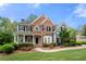 Charming two-story home with a brick and siding exterior, complemented by a well-manicured lawn and mature trees at 4877 Registry Nw Ln, Kennesaw, GA 30152