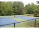 Community tennis courts surrounded by mature trees and a tall chain-link fence at 4877 Registry Nw Ln, Kennesaw, GA 30152