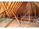 An unfinished attic showing the structural beams and supports with insulation at 1551 Pharrs Rd., Snellville, GA 30078
