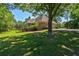 View of the home's backyard highlighting the deck, well-maintained lawn, and mature trees providing shade and privacy at 1551 Pharrs Rd., Snellville, GA 30078