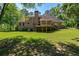 Picture of the home's backyard showcasing a large wooden deck and a lush lawn, ideal for relaxing or entertaining at 1551 Pharrs Rd., Snellville, GA 30078