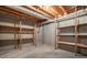 Spacious basement with concrete floor, wooden shelves and exposed pipes ready for your storage needs at 1551 Pharrs Rd., Snellville, GA 30078