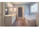 Bright bathroom with double sink vanity, soaking tub, and a stained glass window at 1551 Pharrs Rd., Snellville, GA 30078