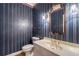 Stylish half bathroom featuring colorful wallpaper, a vanity and ornate lighting at 1551 Pharrs Rd., Snellville, GA 30078