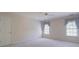 A light-filled bedroom with carpet, ceiling fan, and classic blue window treatments at 1551 Pharrs Rd., Snellville, GA 30078