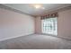 Bedroom featuring carpet flooring, patterned wallpaper, and a large window at 1551 Pharrs Rd., Snellville, GA 30078