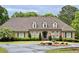 Elegant brick home featuring manicured landscaping, a circular driveway, and a charming water fountain at 1551 Pharrs Rd., Snellville, GA 30078