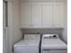Well-lit laundry area features cabinets above the full size washer and dryer at 1551 Pharrs Rd., Snellville, GA 30078