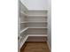 Walk-in pantry featuring sturdy white shelves and hardwood flooring at 1551 Pharrs Rd., Snellville, GA 30078