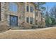 Elegant stone facade featuring a decorative front door, manicured landscaping, and a well-maintained lawn at 2015 Shaudi Ln, Atlanta, GA 30345