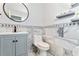 Charming bathroom featuring a gray vanity, decorative mirror, and a toilet with marble-tiled walls at 2949 Lake Spivey Pkwy, Jonesboro, GA 30236