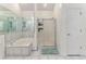 Bathroom with tiled tub, shower, large mirror, and storage at 2949 Lake Spivey Pkwy, Jonesboro, GA 30236