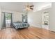 Bright bedroom with hardwood floors, vaulted ceiling, ceiling fan, and two windows with blue curtains at 2949 Lake Spivey Pkwy, Jonesboro, GA 30236