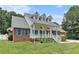 Inviting brick home featuring a classic front porch, white railings, dormer windows, and a well-maintained lawn at 2949 Lake Spivey Pkwy, Jonesboro, GA 30236