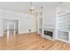 Open living room with hardwood floors, a fireplace, built-in shelving, and an open doorway to the entryway at 2949 Lake Spivey Pkwy, Jonesboro, GA 30236
