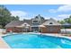 Back exterior view of a brick home with a swimming pool, patio, and outdoor seating areas at 2949 Lake Spivey Pkwy, Jonesboro, GA 30236