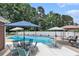 Backyard swimming pool surrounded by patio furniture, a white fence, and mature trees at 2949 Lake Spivey Pkwy, Jonesboro, GA 30236