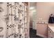 Bright bathroom with decorative shower curtain, black and white tile floor, and neutral pink walls at 3635 Norwich Dr, Tucker, GA 30084