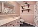 Charming bathroom featuring pink walls, black and white tile floor, white vanity, and floating shelves at 3635 Norwich Dr, Tucker, GA 30084