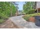 Exterior view of home with long driveway, wooden deck, mature trees, and lush landscaping at 3635 Norwich Dr, Tucker, GA 30084