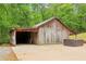 Wide angle view of the wooden barn with an attached carport and an outdoor hot tub surrounded by green foliage at 5250 Aubrey Ln, Cumming, GA 30028