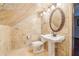 Compact bathroom with a pedestal sink, toilet, and decorative mirror at 5250 Aubrey Ln, Cumming, GA 30028