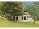 A two-story home featuring a red roof, a black iron balcony, and well-manicured landscaping at 5250 Aubrey Ln, Cumming, GA 30028