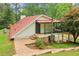 Exterior view of a home with red roof, white siding, stone staircase and patio with black iron railing at 5250 Aubrey Ln, Cumming, GA 30028