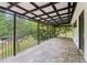 Wide angle view of the spacious patio with stone flooring, covered awning and iron railing overlooking lush greenery at 5250 Aubrey Ln, Cumming, GA 30028