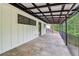 Angle view of a long patio with stone flooring, iron railing and covered awning with a view of green trees at 5250 Aubrey Ln, Cumming, GA 30028