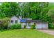 Two-story home with a two-car garage and a lawn surrounded by large trees at 1060 S Millard Way, Stone Mountain, GA 30088