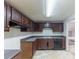 This kitchen features dark wood cabinets, countertops, double sink, and black dishwasher at 1060 S Millard Way, Stone Mountain, GA 30088