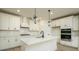 Bright, modern kitchen featuring white cabinets, island with pendant lights, and stainless appliances at 1510 Gatekeeper Ter, Marietta, GA 30066