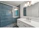 Updated bathroom with blue tiled walk-in shower, white vanity, and modern fixtures at 1773 Kimberly Sw Dr, Marietta, GA 30008